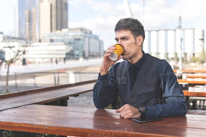 Businessman sitting at an outdoor bar having a coffee