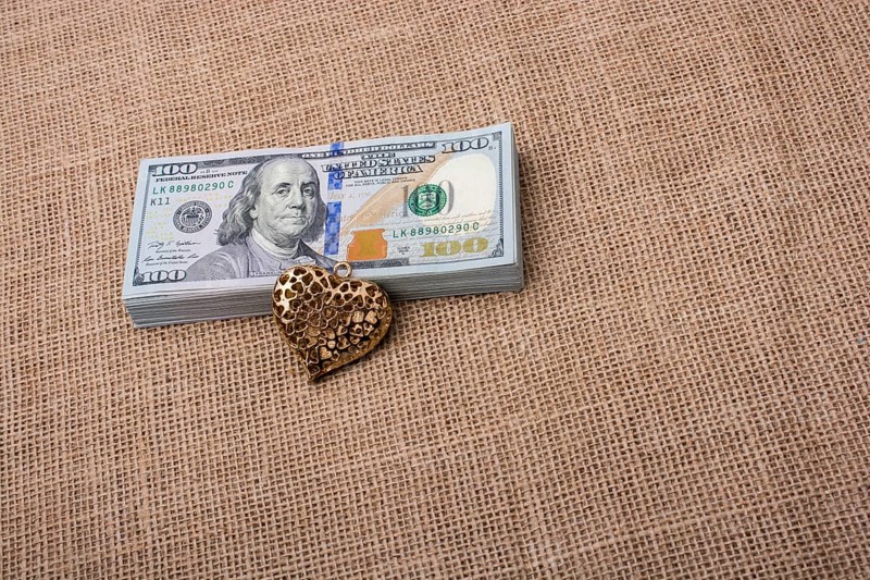 Heart icon bundle of US dollar placed on a linen canvas