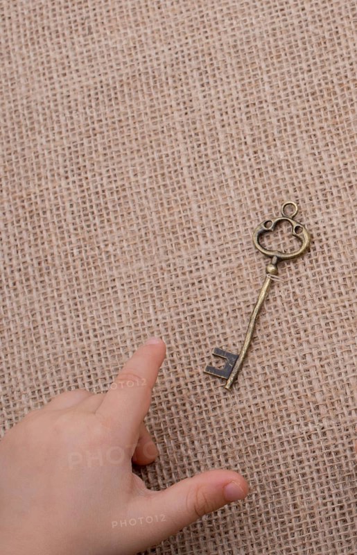 Heart shaped gold color metal object in hand