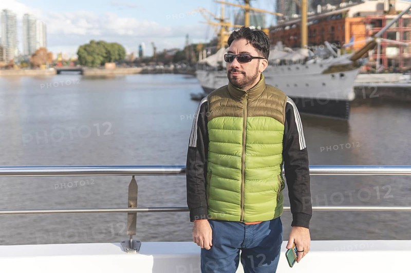 Happy tourist posing in front of a boat in Puerto Madero