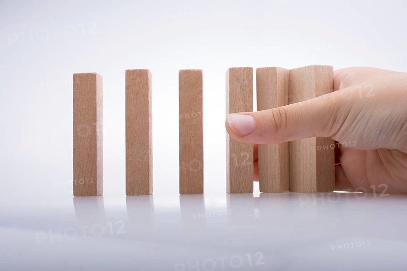 Hand holding wooden domino on a white background