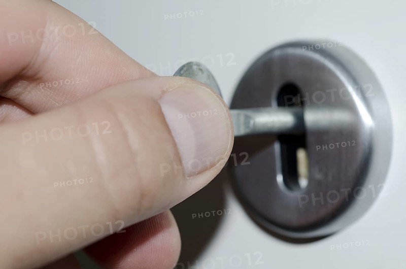Hand Turns the Key in the Lock