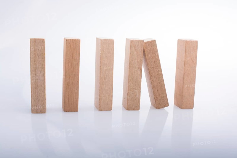 Wooden Domino Blocks in a line on a white background