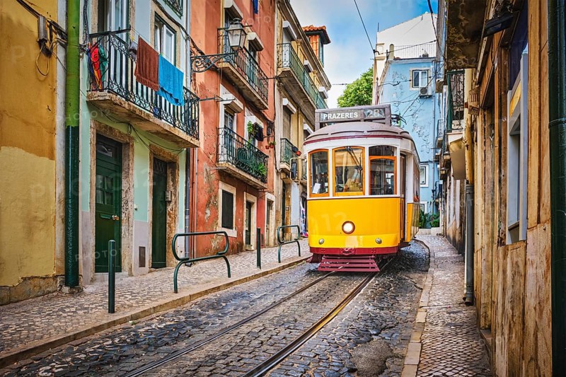 Famous vintage yellow tram 28 in the narrow streets of Alfama district in Lisbon