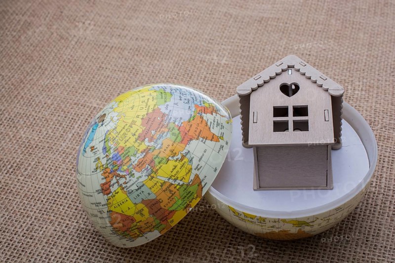Model house and a globe on a linen canvas
