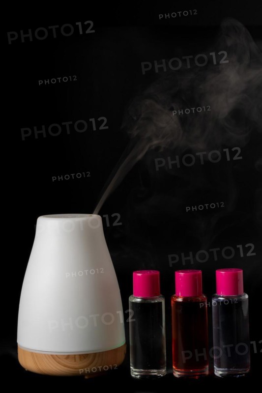 Aroma humidifier steaming with scent pots isolated on a black background
