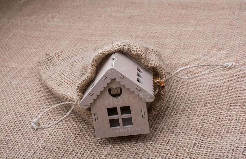 Model house beside a sack on a canvas background
