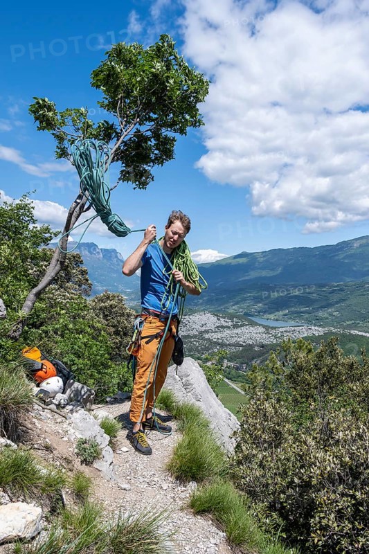 Climber throws climbing rope over his shoulder
