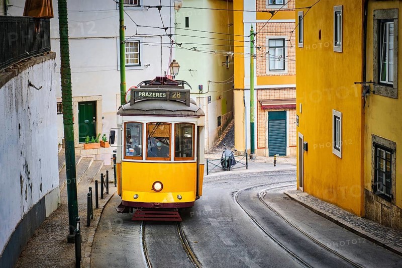 Famous vintage yellow tram 28 in the narrow streets of Alfama district in Lisbon