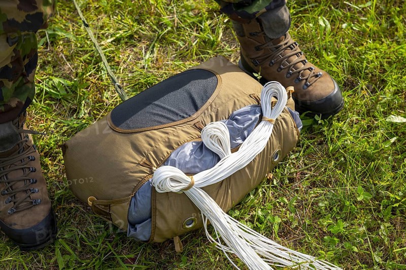 Military Parachuter Standing on the Grass with His Parachute in Switzerland