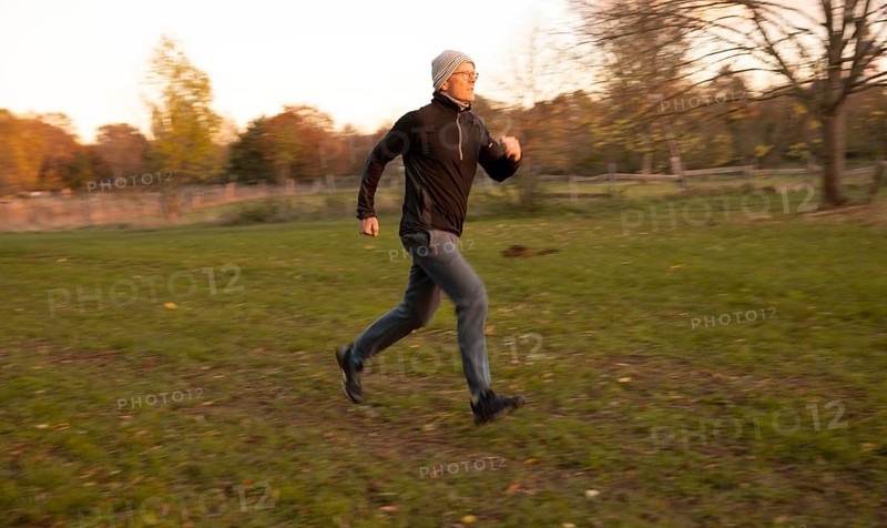 Man doing early morning exercise in autumn in a meadow.