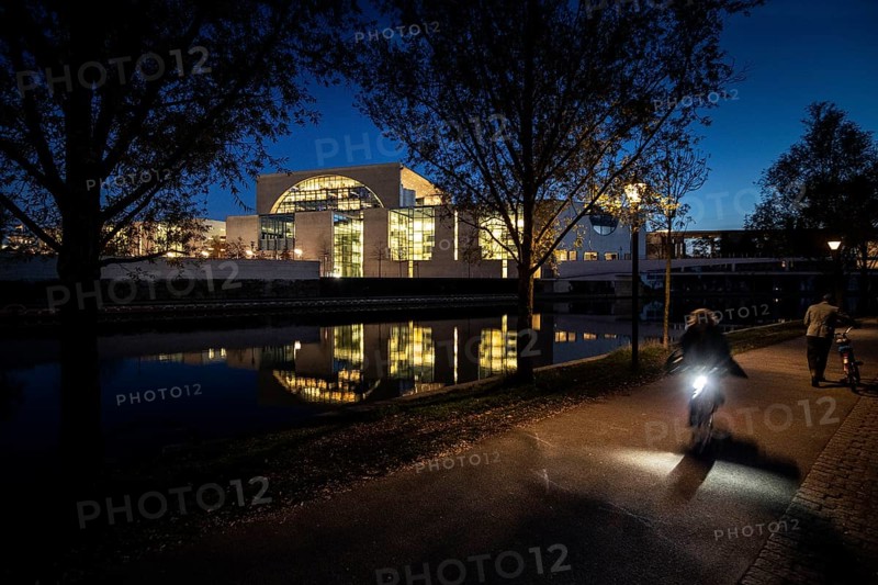 Cyclists in front of the Federal Chancellery at blue hour