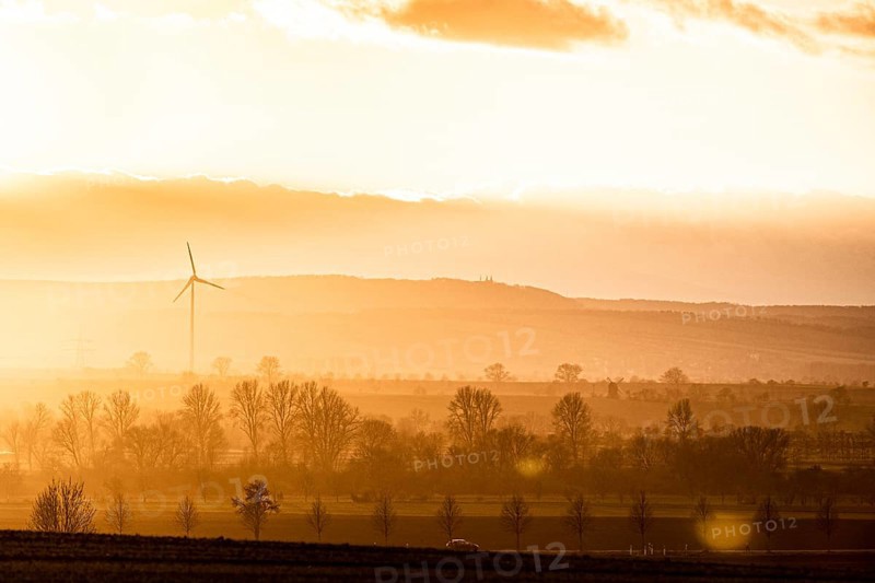 A car driving along a country road in the evening light near Oschersleben