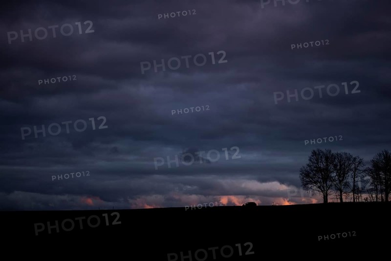 A car stands out on a country road at blue hour in Vierkirchen