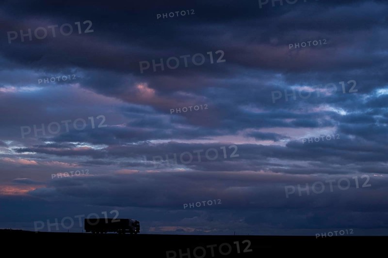A lorry stands out on a country road at blue hour in Vierkirchen