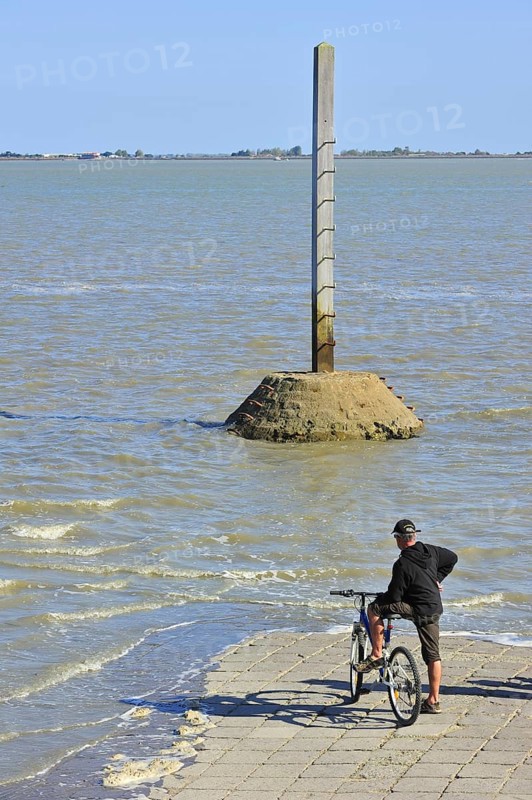 Tourist waiting for low tide to uncover the Passage du Gois