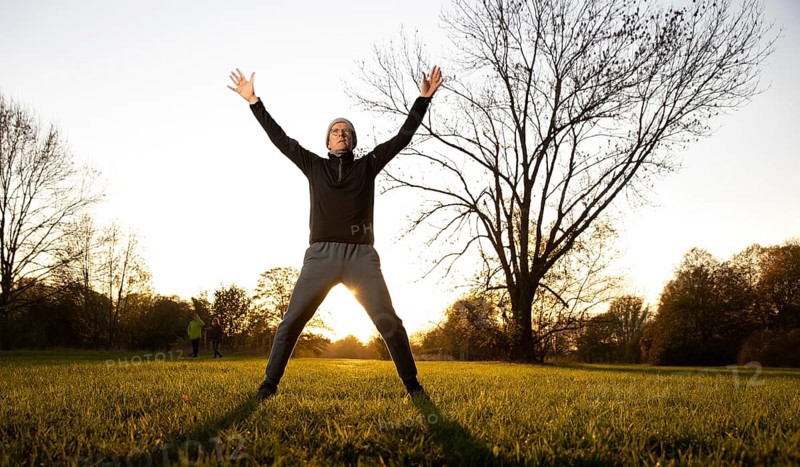 Man doing early morning exercise in autumn in a meadow.