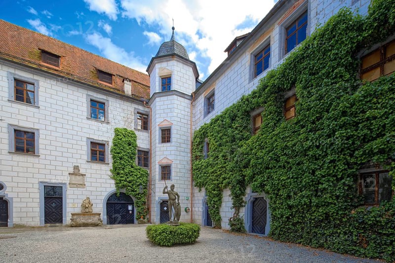 Inner courtyard of Mitwitz moated castle with Neptune fountain and sandstone statue of The Franconian Knight
