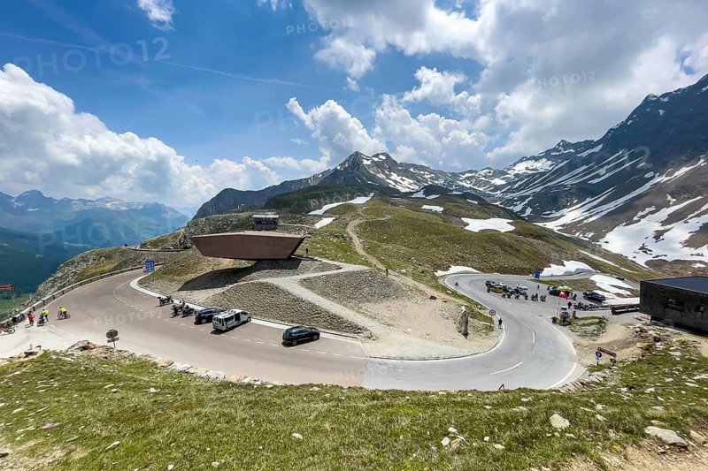 View on pass road alpine pass mountain road pass height of 2509 metres high Timmelsjoch Passo Rombo with pass museum from right Austrian territory to left in air of Italian territory