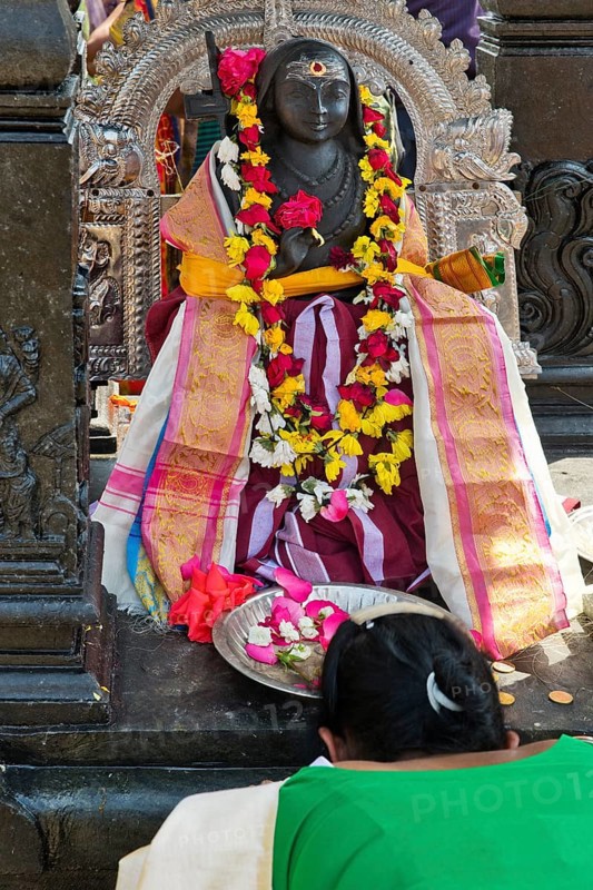 A woman bows to a goddess at the temple festival