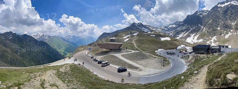 Panoramic view of pass road Alpine pass mountain road pass height of 2509 metres high Timmelsjoch Passo Rombo with pass museum rises from right Austrian territory to left in air of Italian territory