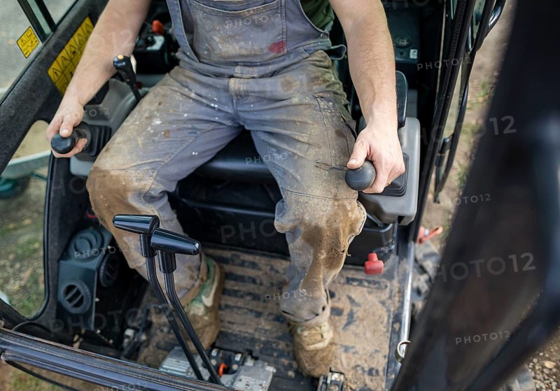 A construction worker controls the levers of an excavator. Berlin