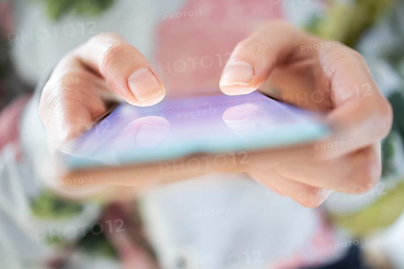 Symbolic photo on the subject of mobile phone addiction. A woman typing on a smartphone. Berlin
