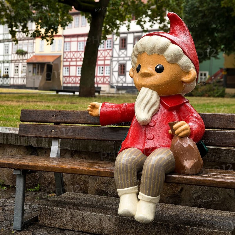 Sculpture of the Sandman on a bench in front of half-timbered houses on Kraemerbruecke in Erfurt
