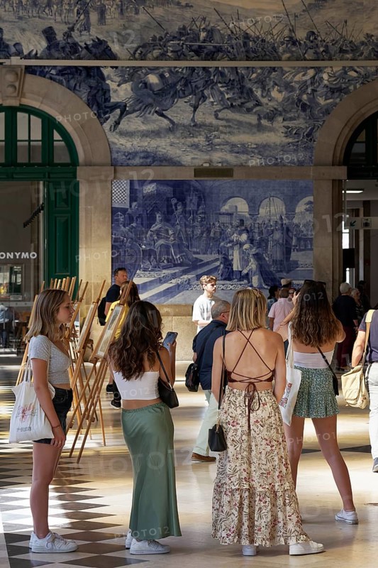 Young female tourist looking at the azulejos at Porto Sao Bento station