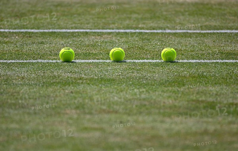 Three tennis balls lie on grass