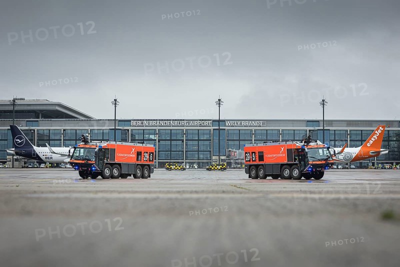Two vehicles of the airport fire brigade drive across the tarmac during the opening of Terminal 1 at Berlin Brandenburg Willy Brandt Airport