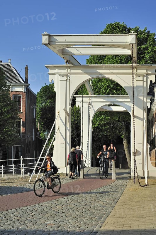 Cyclists crossing drawbridge at the Noordhavenpoort in the old harbour at Zierikzee
