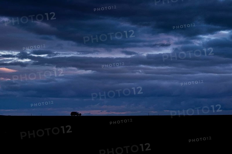 A car stands out on a country road at blue hour in Vierkirchen