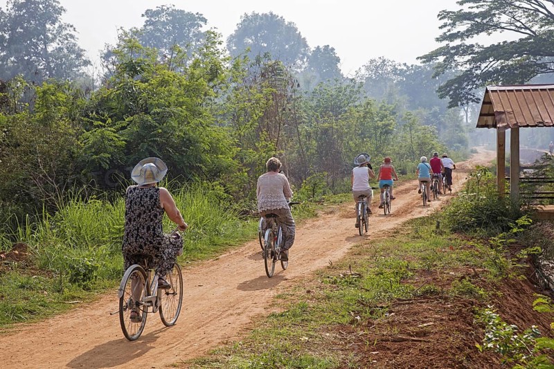 Western tourists cycling on bicycles near the Inle lake in the Nyaungshwe Township of Taunggyi District