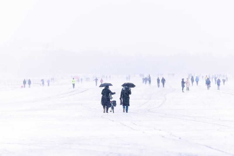 Berliners walk across Tempelhofer Feld in Berlin during snowfall