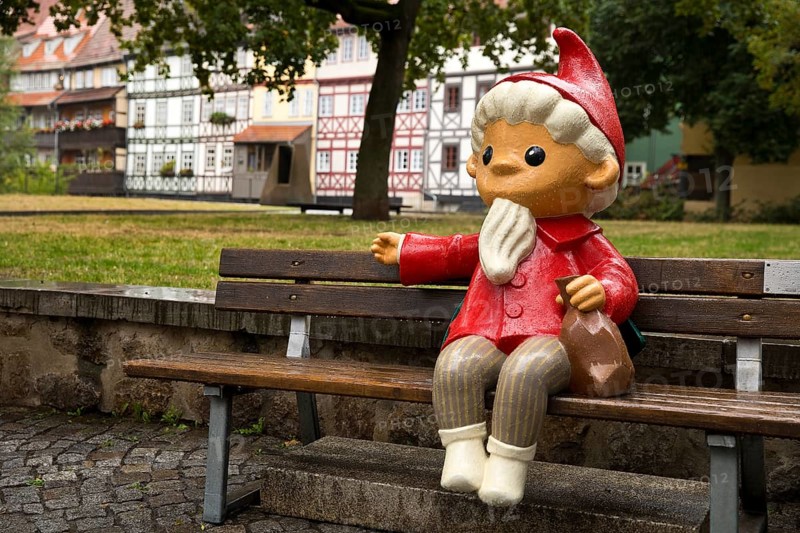 Sculpture of the Sandman on a bench in front of half-timbered houses on Kraemerbruecke in Erfurt