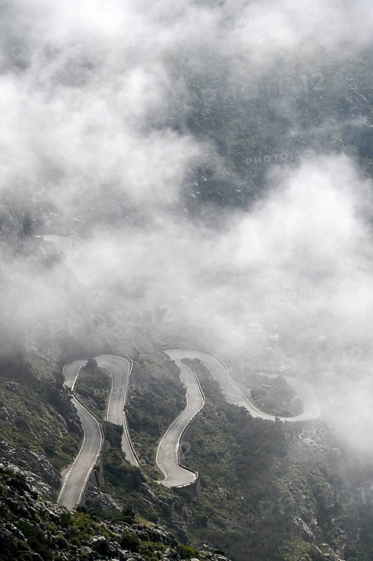 The winding road from Sa Calobra to Coll dels Reis in the Tramuntana Mountains with clouds