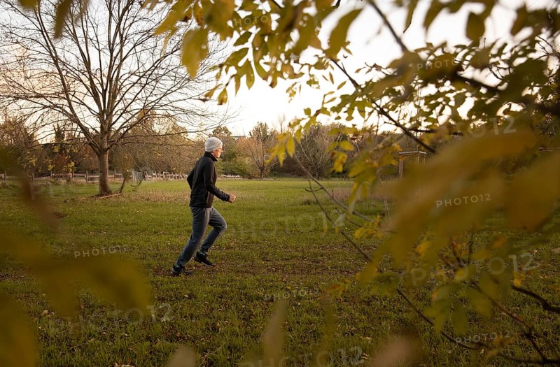 Man doing early morning exercise in autumn in a meadow.