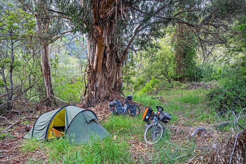 Touring cyclists wild camping with dome tent in Topanga State Park in the Santa Monica Mountains