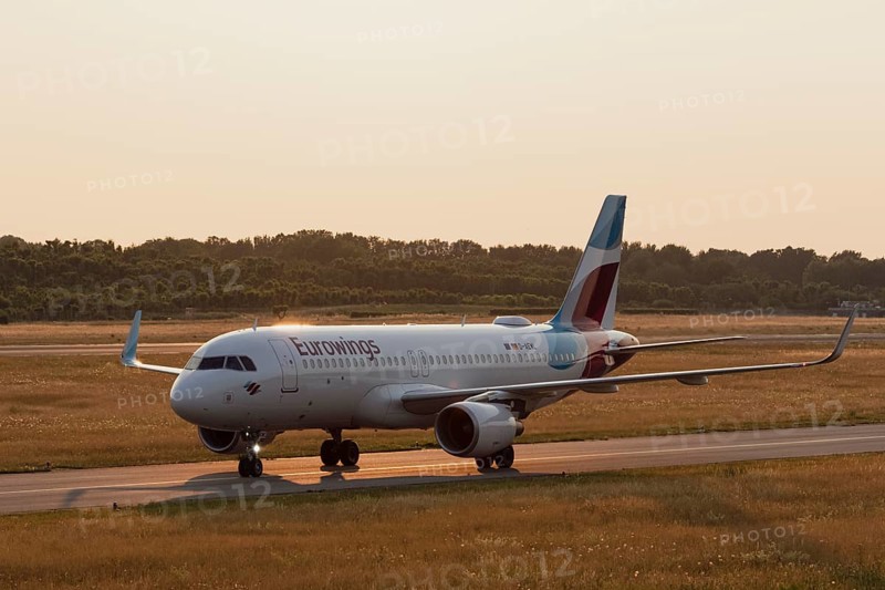 Passenger aircraft Airbus A320-214 of the airline Eurowings in the evening light on the tarmac at Hamburg Airport