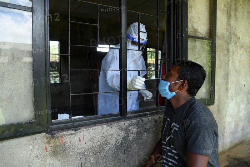 Health worker collects swab sample to test for COVID-19 coronavirus disease during a vaccination drive on the outskirt of Guwahati in India on Monday