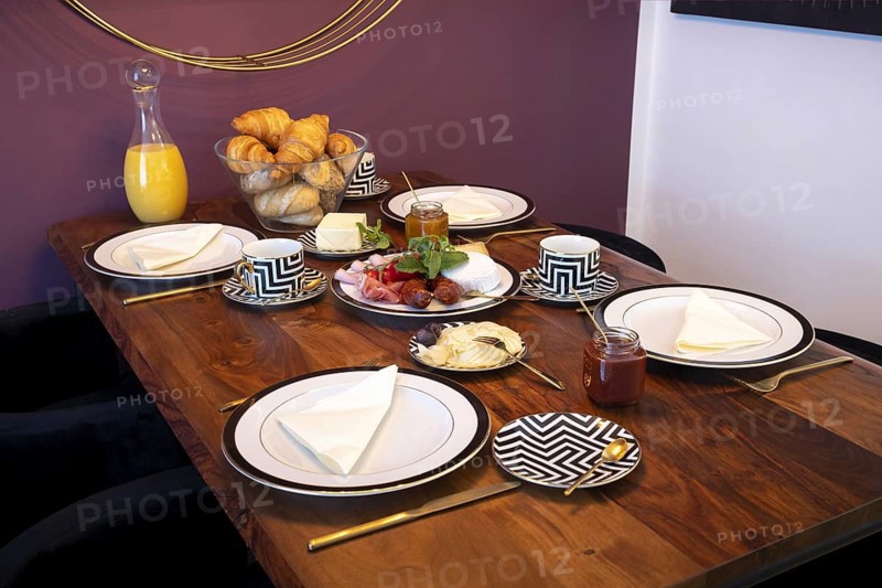 Set dining table with golden cutlery and a cheese and sausage platter