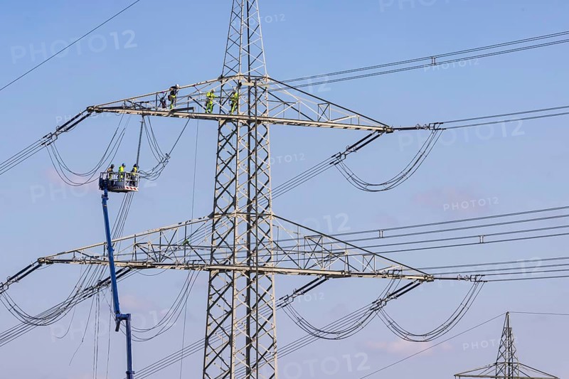 High-voltage pylon with fitters with cherry picker