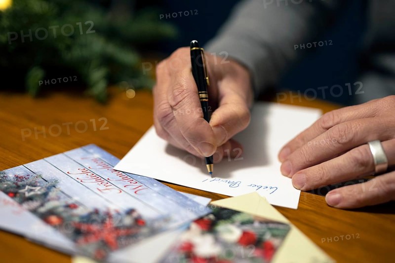 Merry Christmas. Man writes Christmas cards by hand
