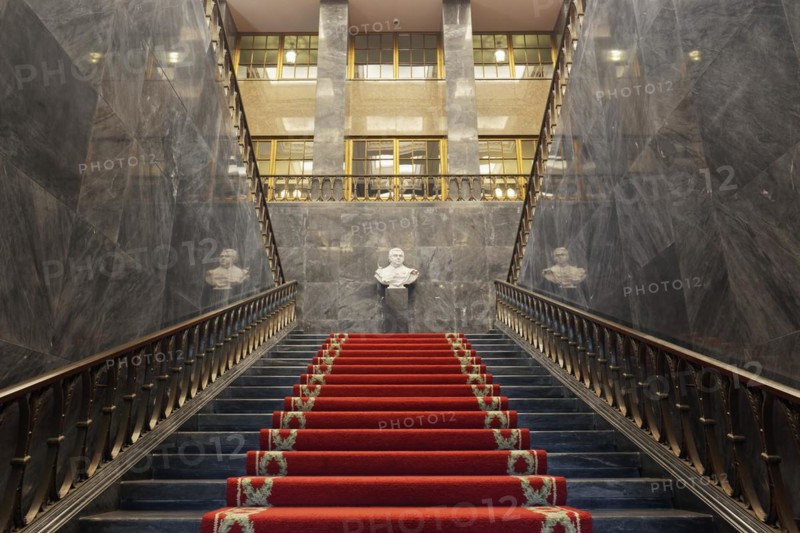 Pompous black marble staircase with red carpet
