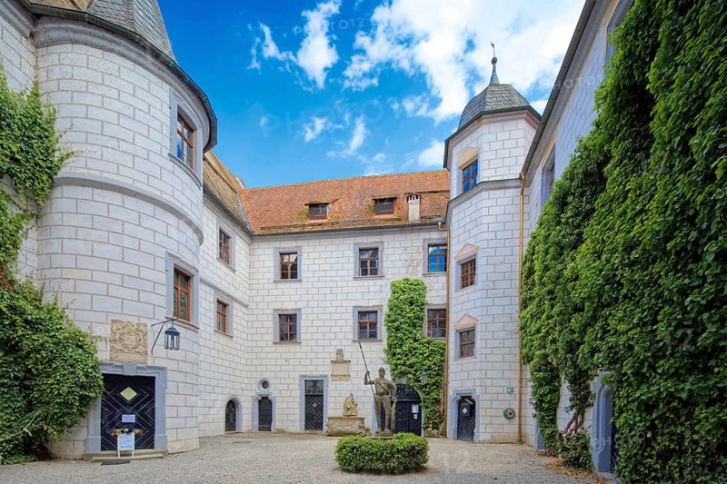 Inner courtyard of Mitwitz moated castle with Neptune fountain and sandstone statue of The Franconian Knight