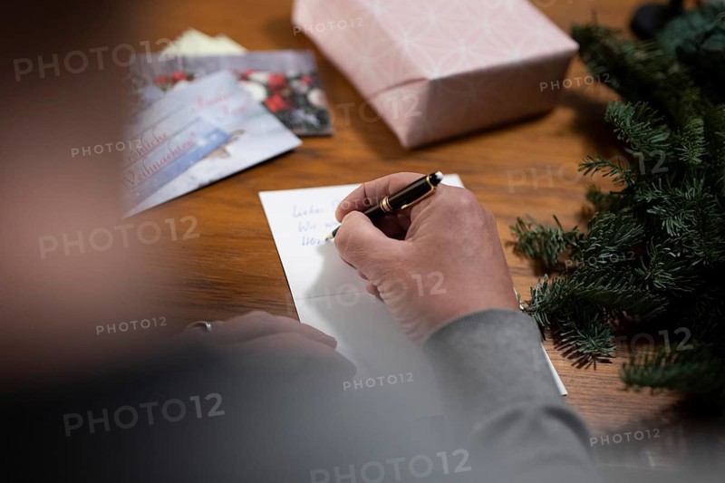 Merry Christmas. Man writes Christmas cards by hand
