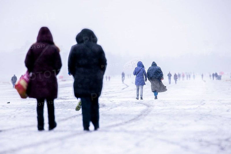 Berliners walk across Tempelhofer Feld in Berlin during snowfall