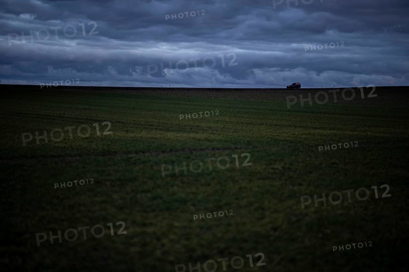 A car stands out on a country road at blue hour in Vierkirchen