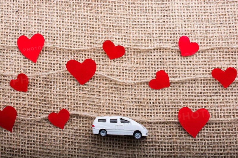 Love concept with car and paper heart on linen threads